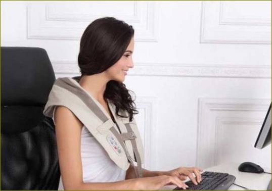 Ein Mädchen arbeitet an ihrem Computer mit einem Schultermassagegerät