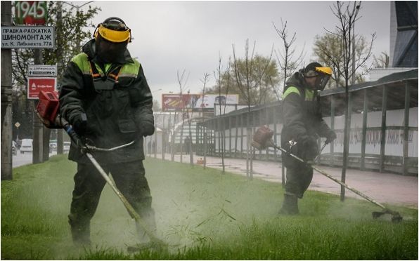 Mähen von Gras bei regnerischem Wetter